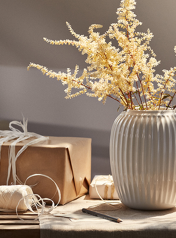 Blomster i en vase og gaver på et bord