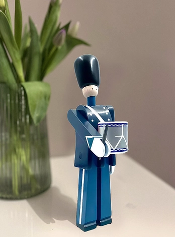 Kay Bojesen trommesalger foran en vase med tulipaner